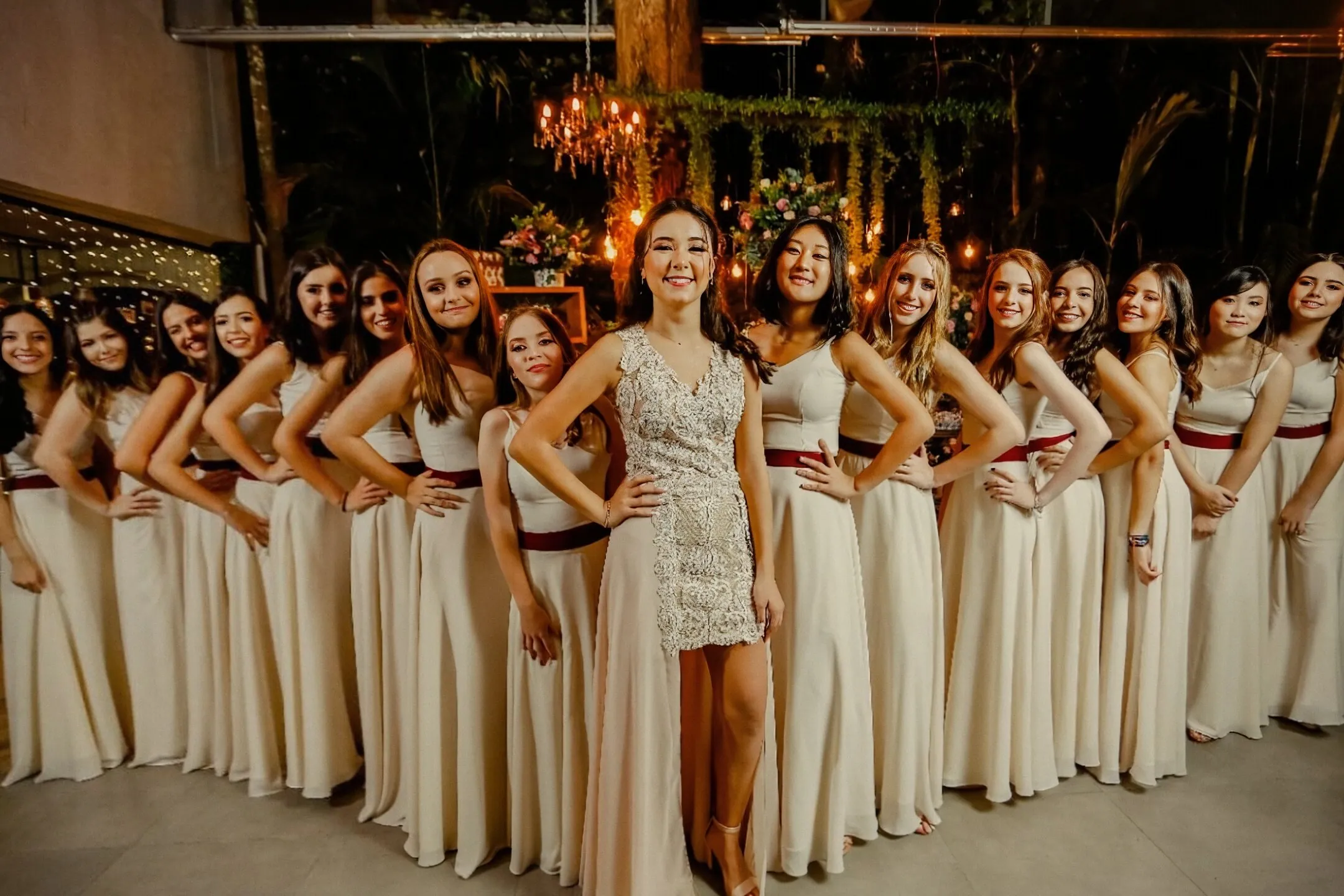 Debutante sob arco floral com decoração de luzes no Espaço Cedrom